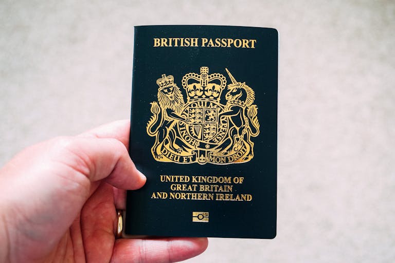 Close-up of a hand holding a British passport, symbolizing citizenship and travel.