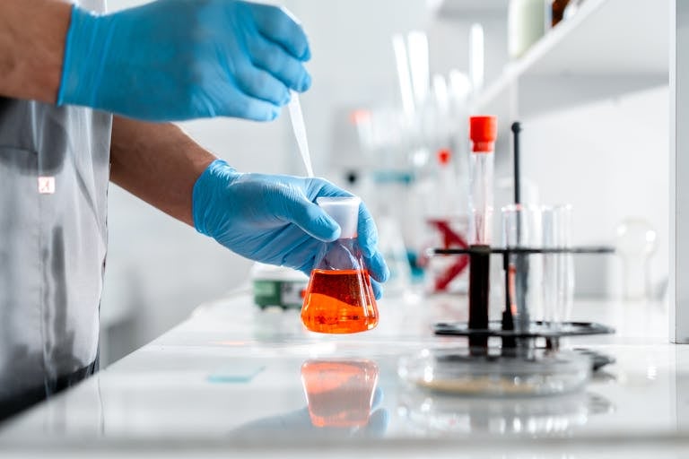 Veterinarian carefully working with flask and pipette in a veterinary laboratory.